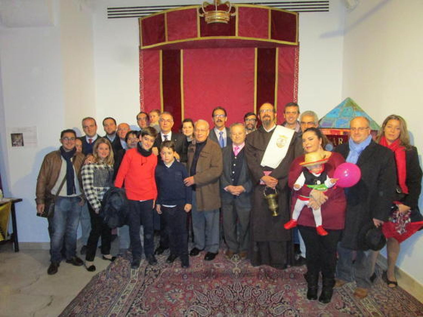 Los padres de la orden carmelitana Ángel Noberto Palomino y Carlos Quijano, con un grupo de miembros de la hermandad del Carmen, que acudieron ayer al acto de bedición del nacimiento que la propia cofradía ha instalado en la sede de la Fundación Cajasol, en la plaza de San Antonio, en Cádiz.  Foto: Ignacio Casas de Ciria