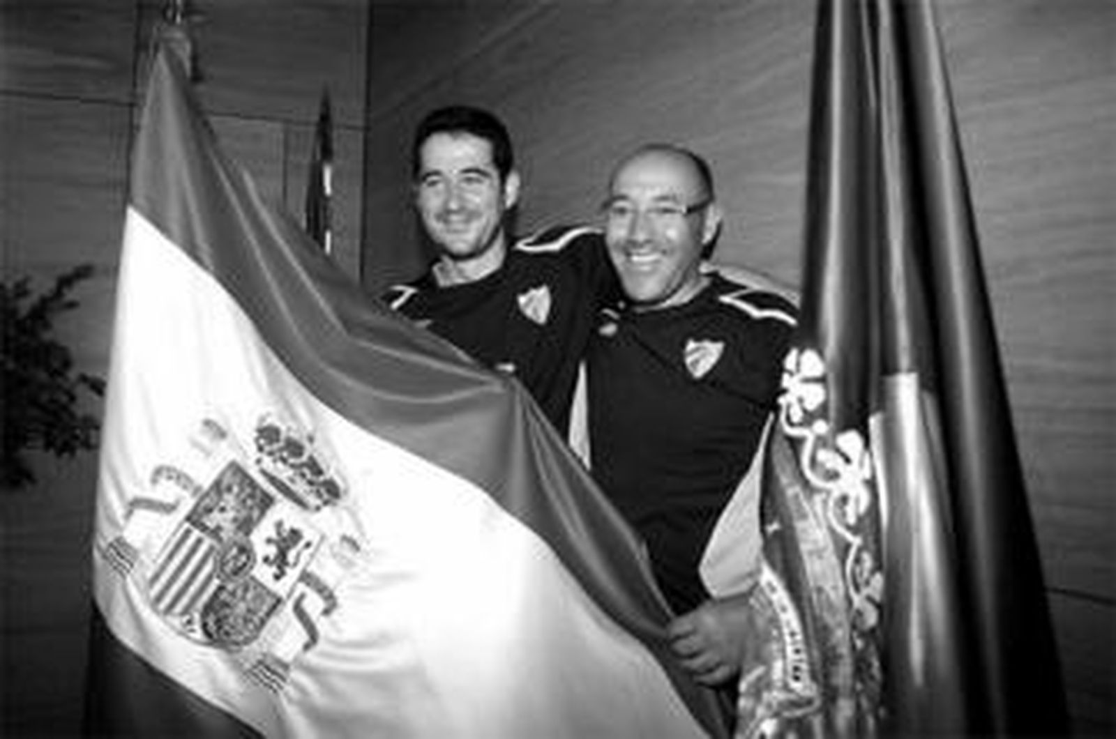 Fernando Lacomba y Marcelino Torrontegui posan con la bandera de España, ayer, en La Rosaleda.