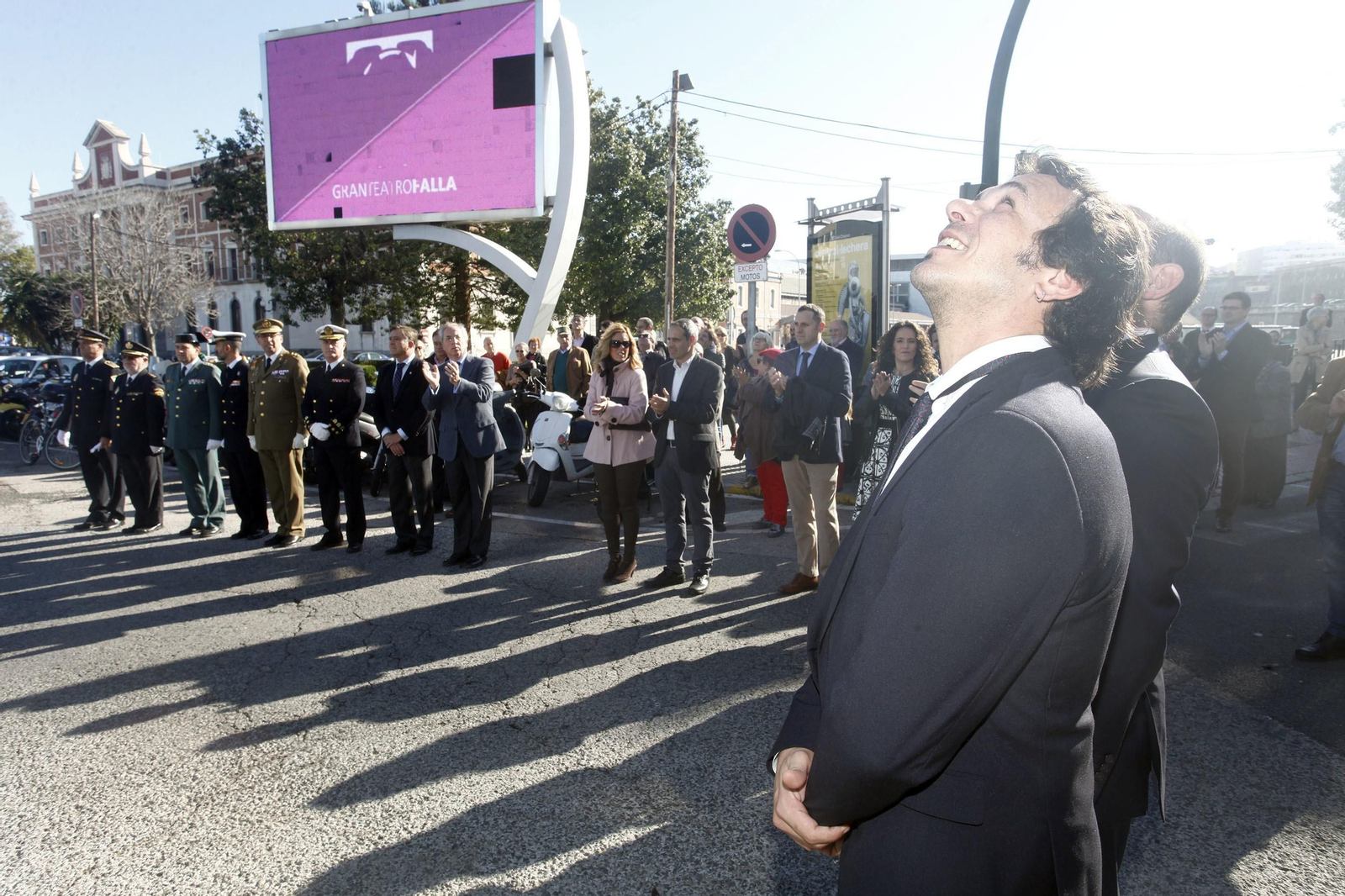 El alcalde y el resto de las autoridades siguen el izado de la bandera en la plaza de Sevilla.