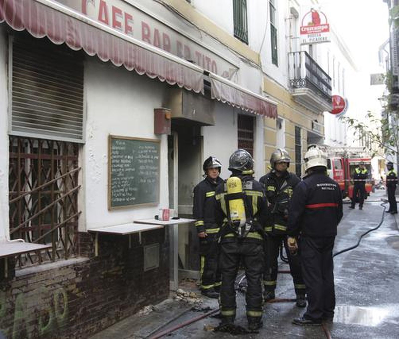 Los bomberos en la puerta del local incendiado.

Foto: Ruesga Bono/José Ángel García