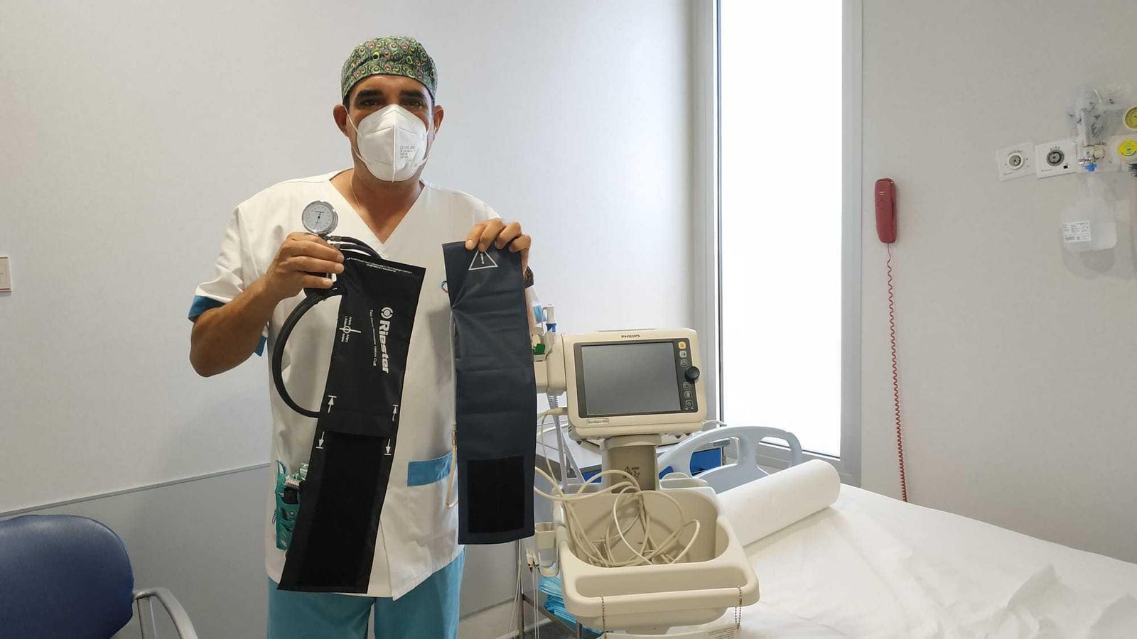 Uno de los integrantes del equipo de investigación, José Miguel Garrido Molina, con un esfigmomanómetro donde se puede apreciar el brazalete para el que se ha diseñado la funda de un solo uso.