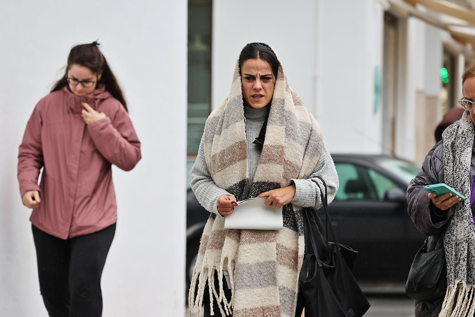 Una mujer trata de protegerse del frío usando su bufanda.