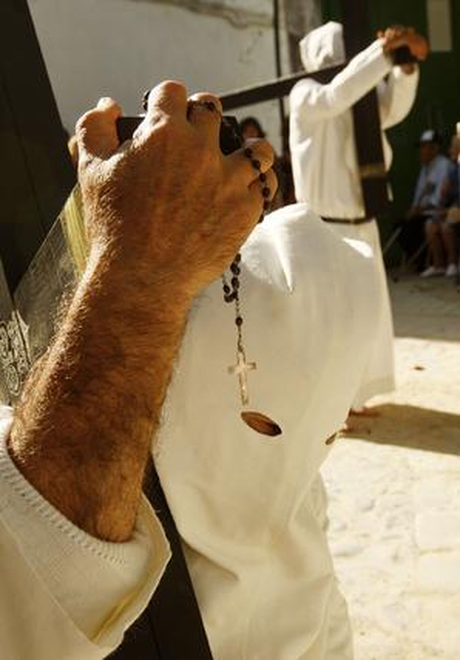 penitencia. Un nazareno del Transporte reza el Rosario con una cruz de penitencia sobre sus hombros.

Foto: Juan Carlos Toro