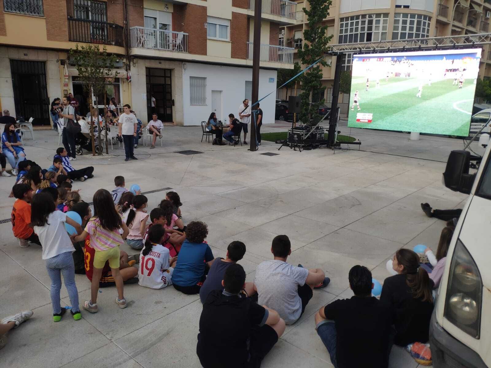 Varios aficionados presencian el partido de semifinales en la pantalla gigante.