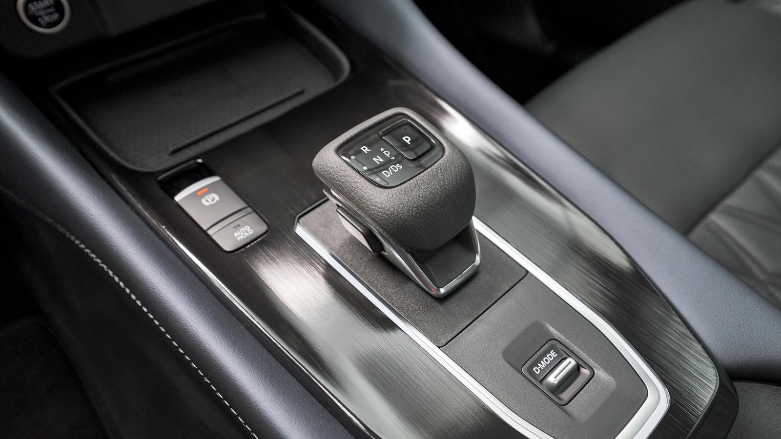 La tecla basculante situada tras el cambio permite variar el funcionamiento de algunos elementos, como dirección, respuesta del motor o el propio cambio.