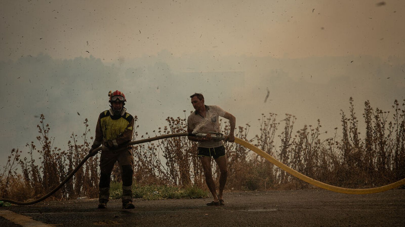 Un vecino ayuda a un bombero.
