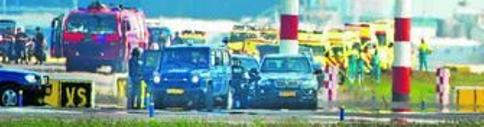 Miembros de los equipos especiales de seguridad observan a los pasajeros que descienden del avión de Vueling.