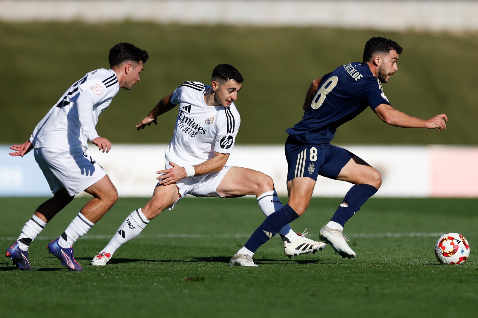 Luis Alcalde se va de dos rivales durante el partido con el Real Madrid Castilla.