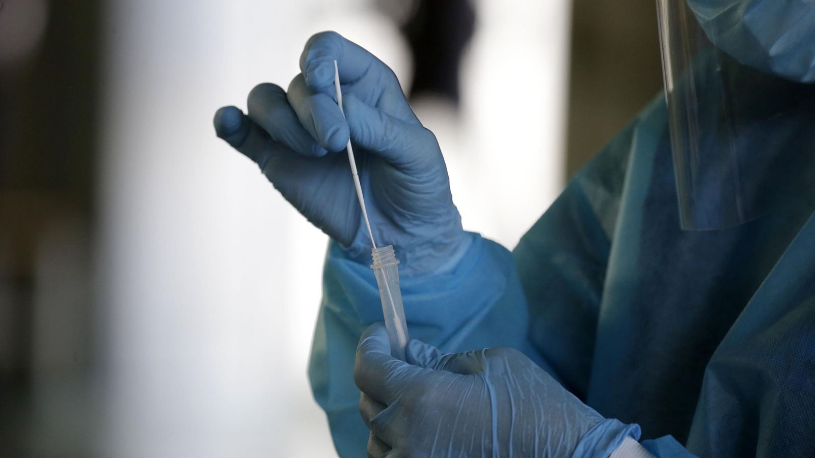 Un sanitario recoge una muestra para un test de covid.