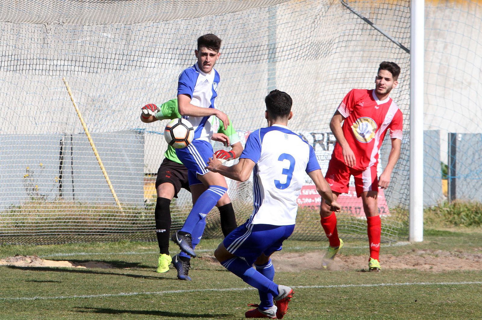 Arias mira un balón pasado tras un centro lateral ante su compañero Moi y el palmerino Juan Aguilar