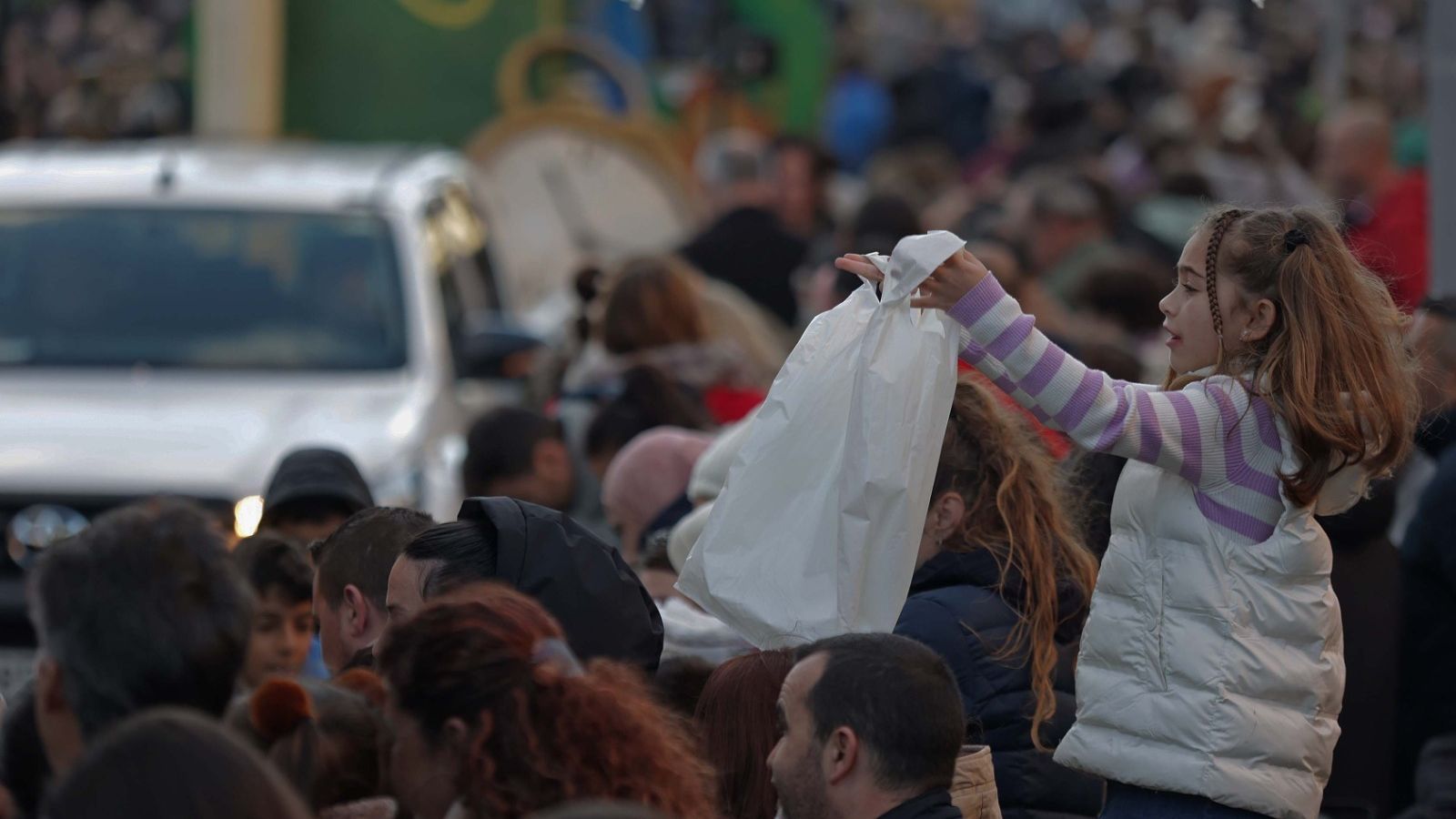 Una niña recoge caramelos en la cabalgata de Algeciras.
