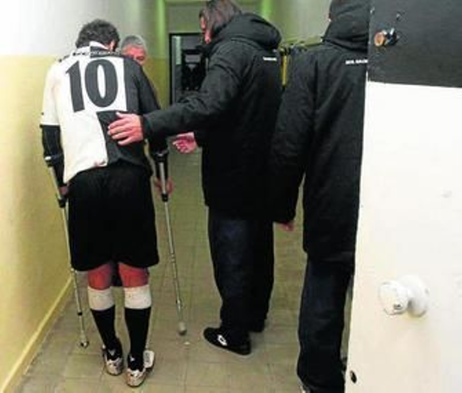 Alberto Merino ayuda a caminar a David Hernández, con muletas.