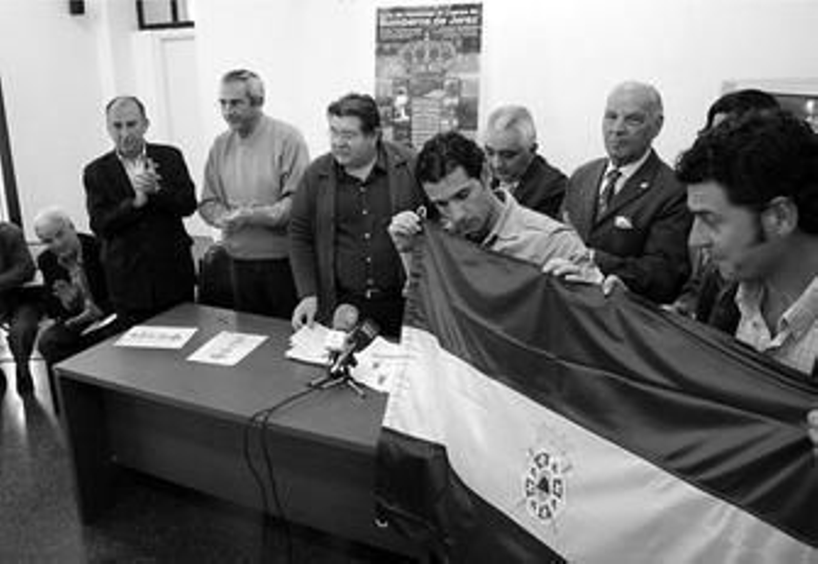 Dos bomberos sujentan ayer la bandera que el comité les ha regalado con motivo del homenaje.