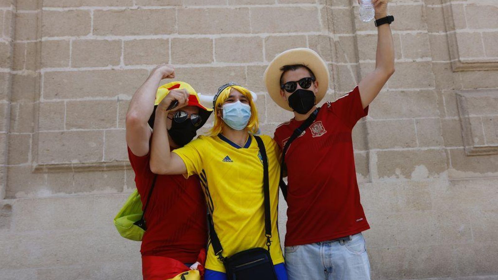 Tres aficionados de ambas selecciones junto a la Catedral.