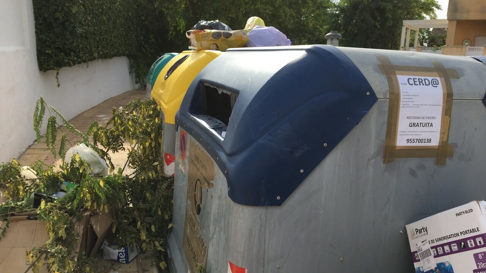 Contenedores con un cartel, recriminando a los vecinos que dejen la basura en cualquier parte.