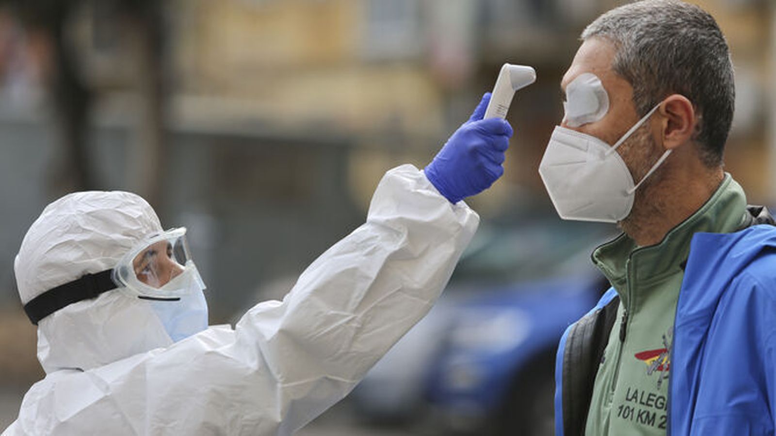 Un sanitario toma la temperatura a un hombre