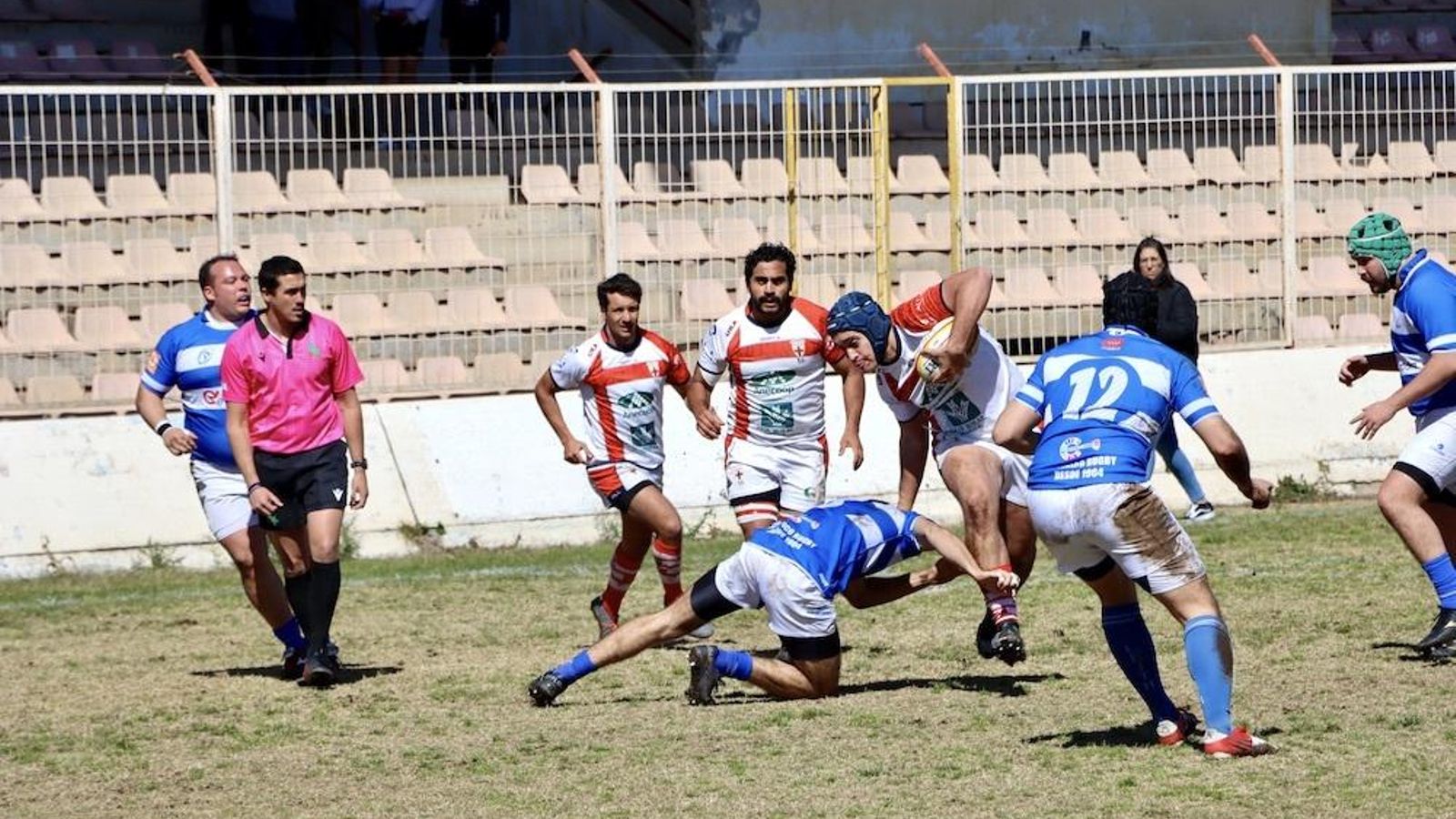 Un jugador cruzado intenta sortear el placaje de un rival.