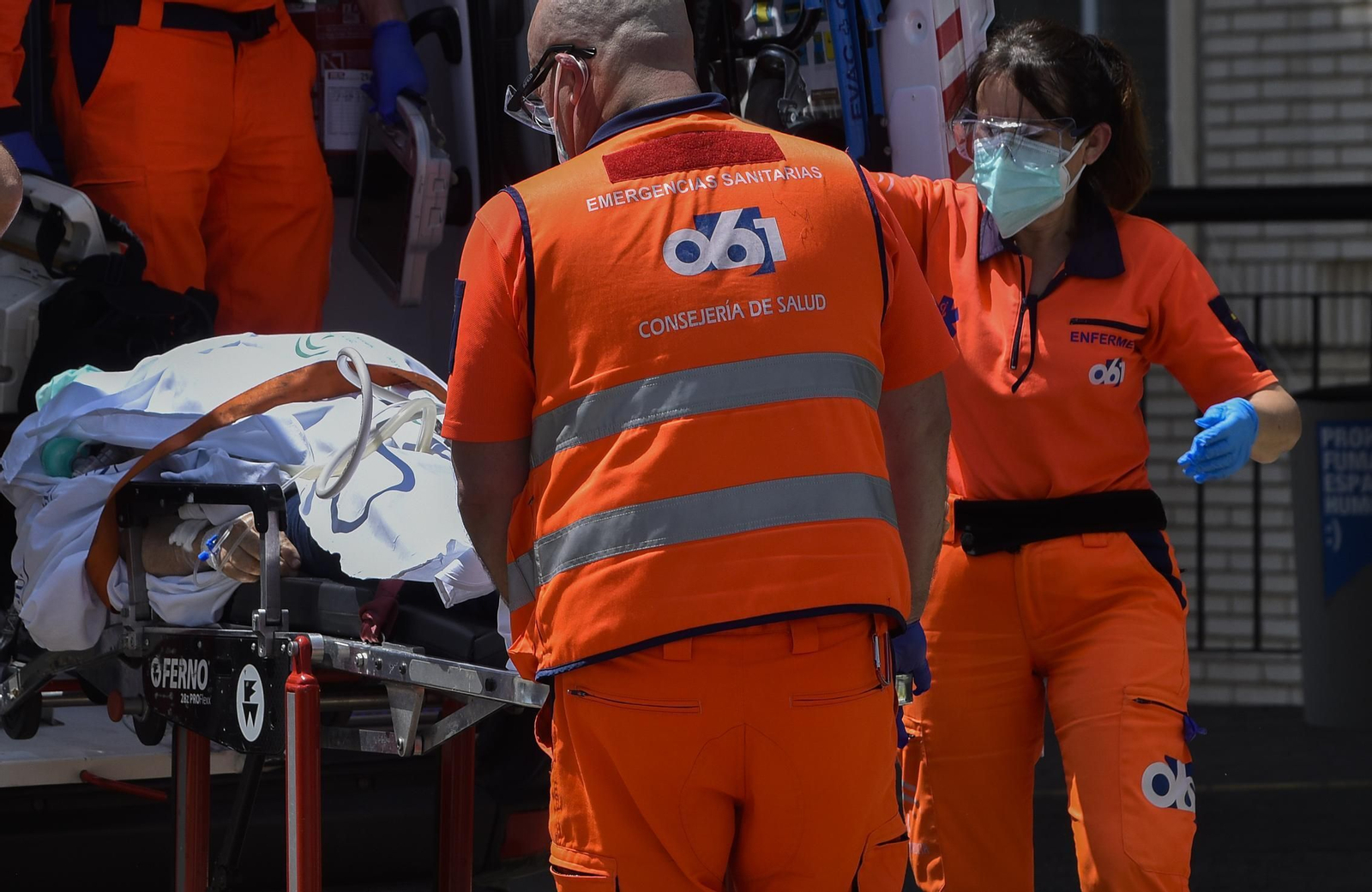 Dos sanitarios del 061 trasladan a un enfermo a un hospital.