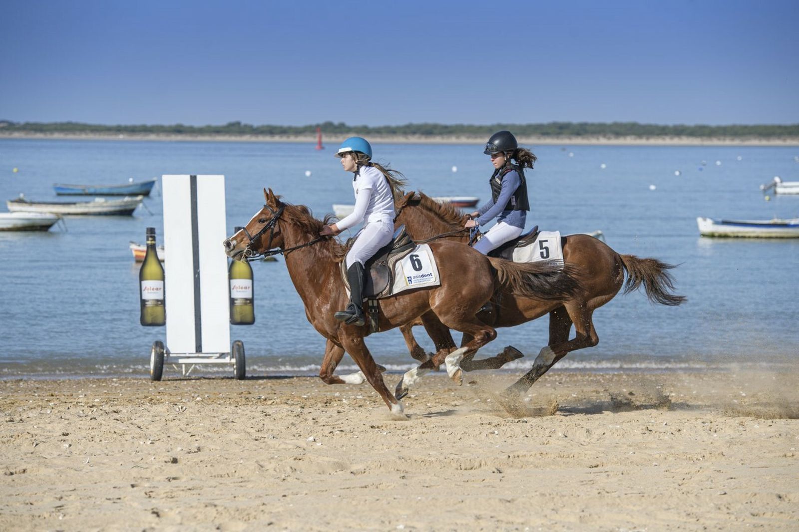 Apretada llegada de una de las carreras en la playa para aficionados.