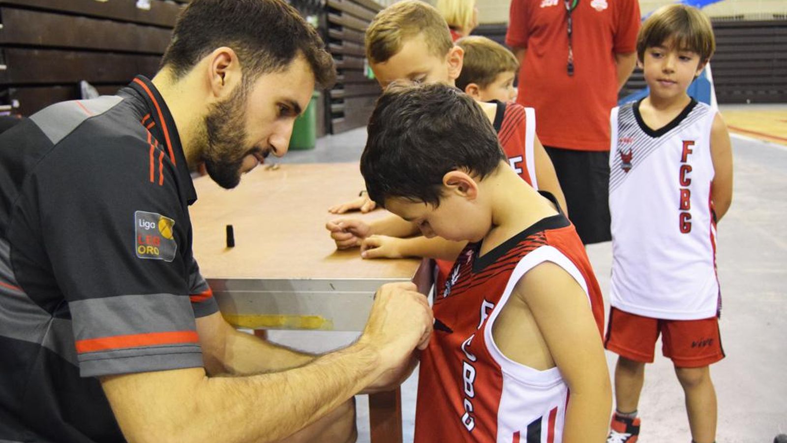 Manu Rodriguez estampa su firma en la camiseta de un niño