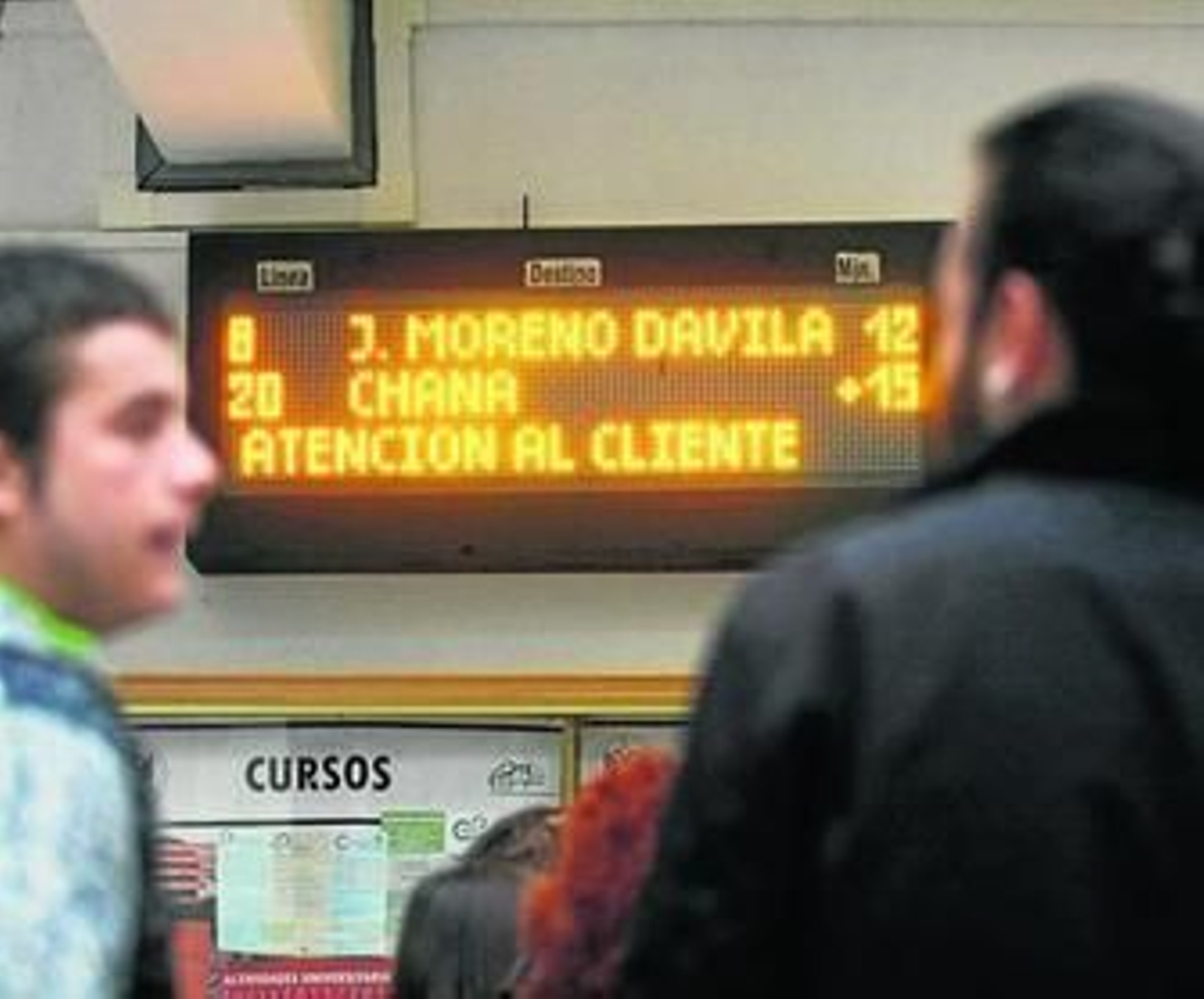Dos estudiantes observan el nuevo panel informativo de las líneas de autobuses.
