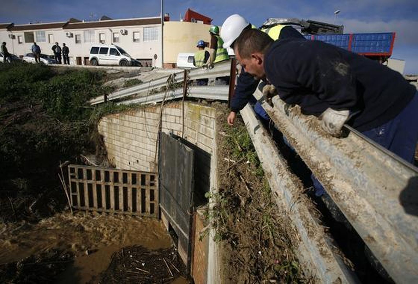 Los trabajadores trabajan en la compuerta para evitar unas nuevas inundaciones en Écija ante la previsión de lluvias.  Foto: Antonio Pizarro