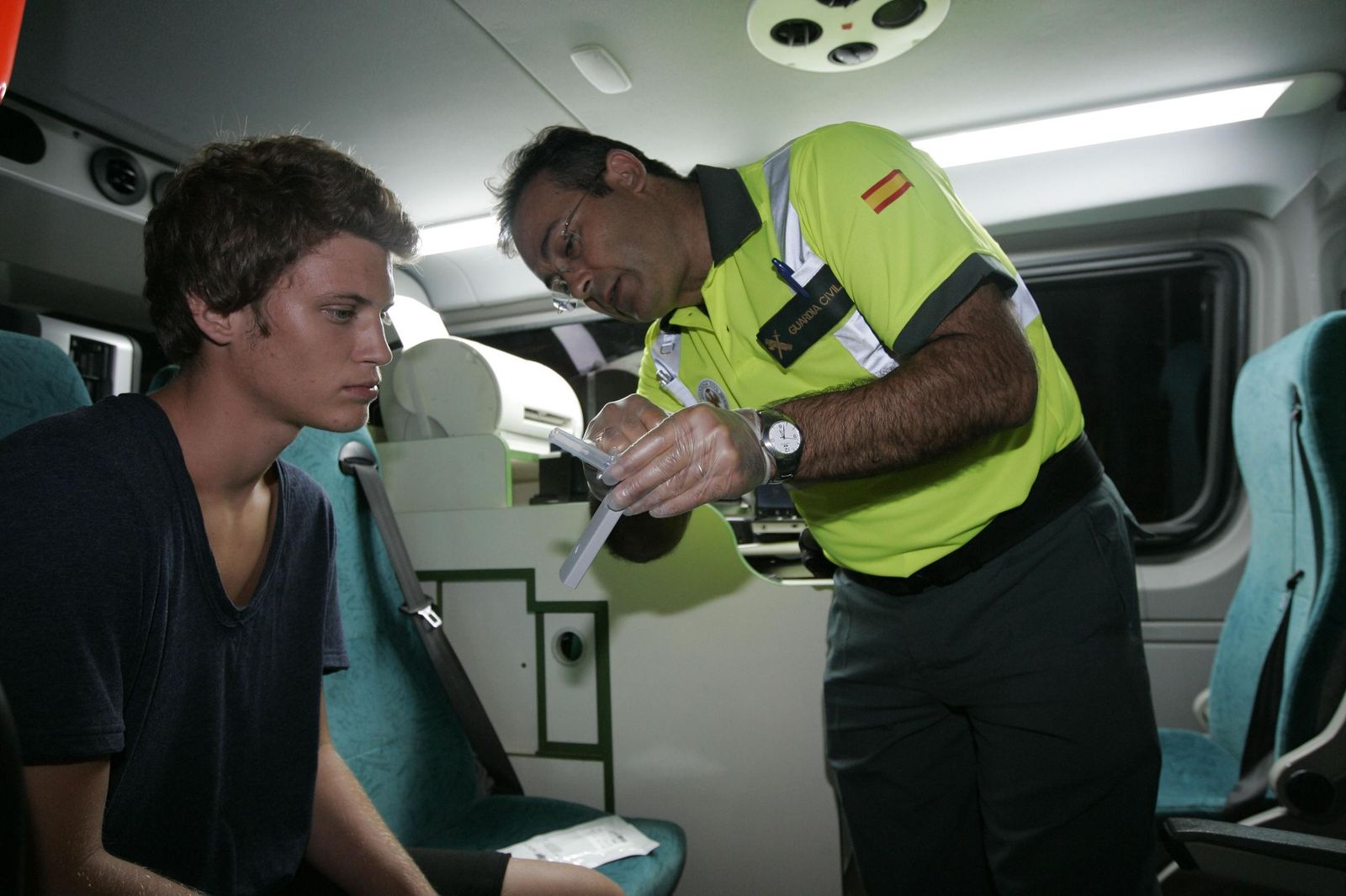 Un agente de la Agrupación de Tráfico de la Guardia Civil realiza un test de drogas a un joven que dio negativo.