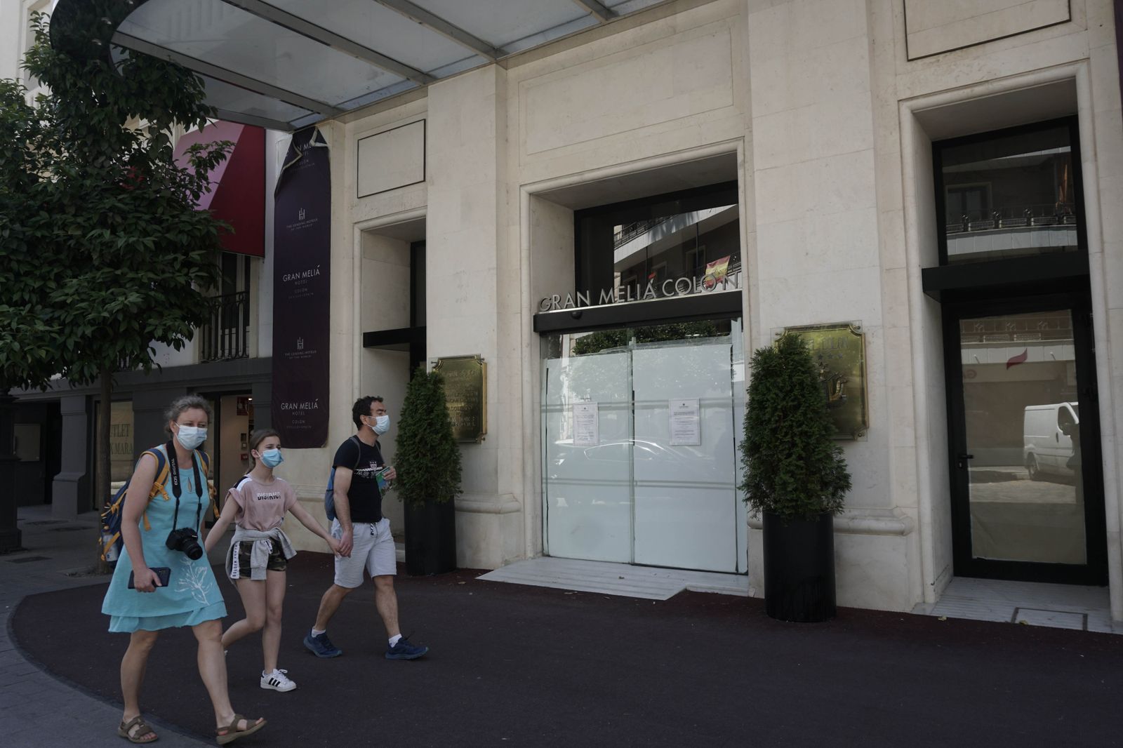 Varios turistas pasan ante las puertas del Hotel Colón.