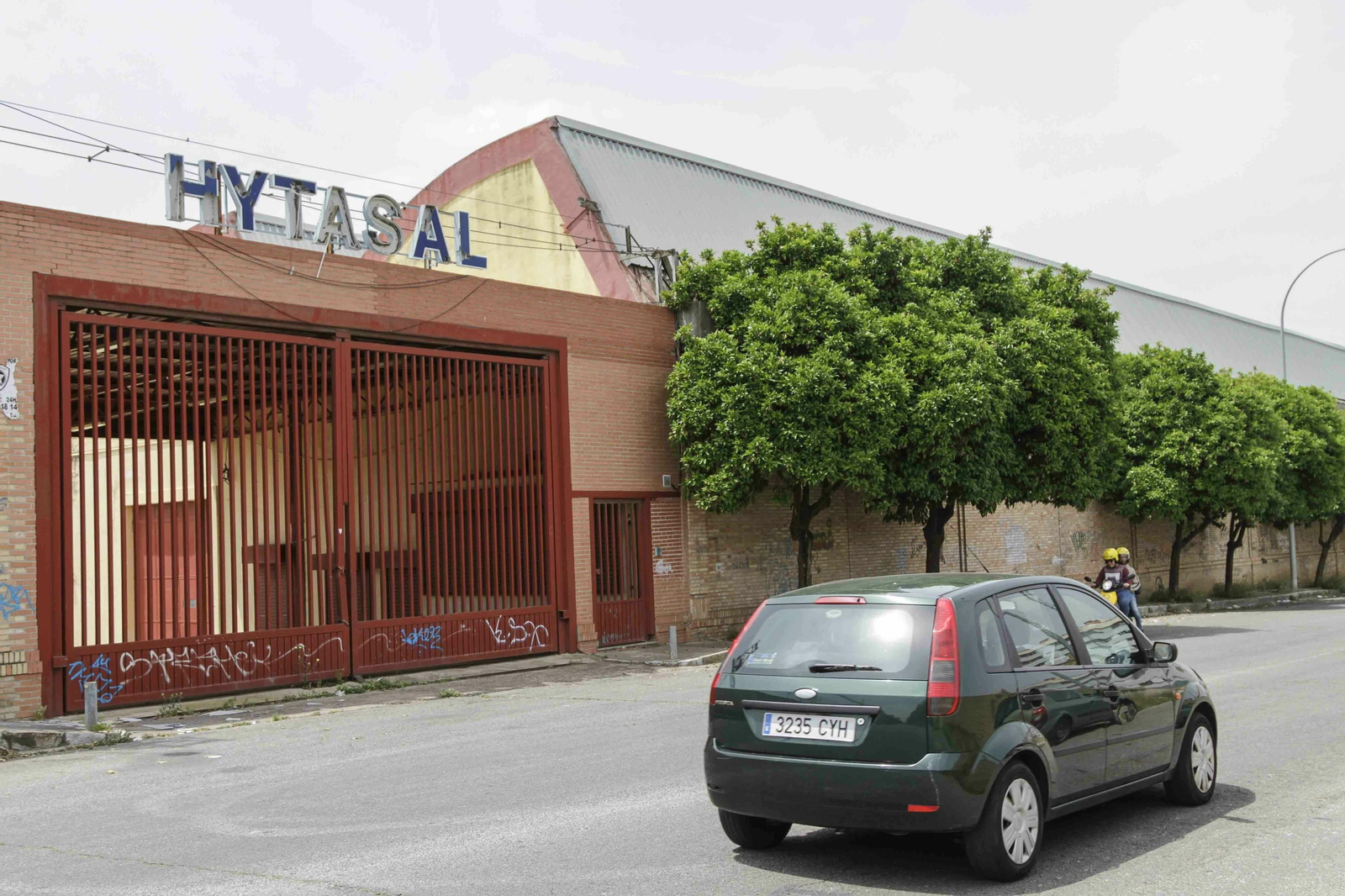 Un coche y una moto coinciden en la entrada principal de las antiguas naves de Hytasa.