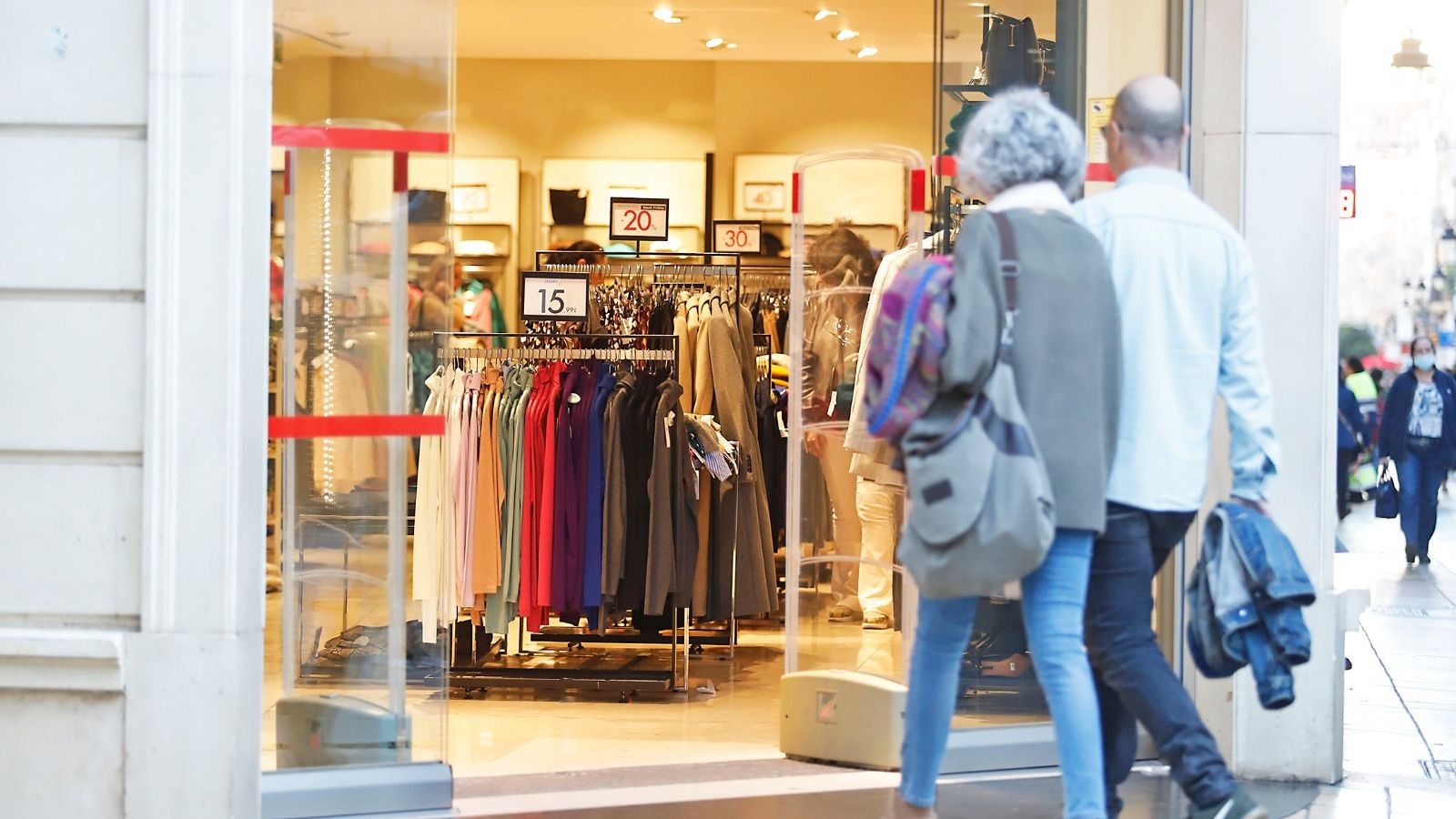 Una pareja entrando en un comercio del centro de Huelva durante el Black Friday
