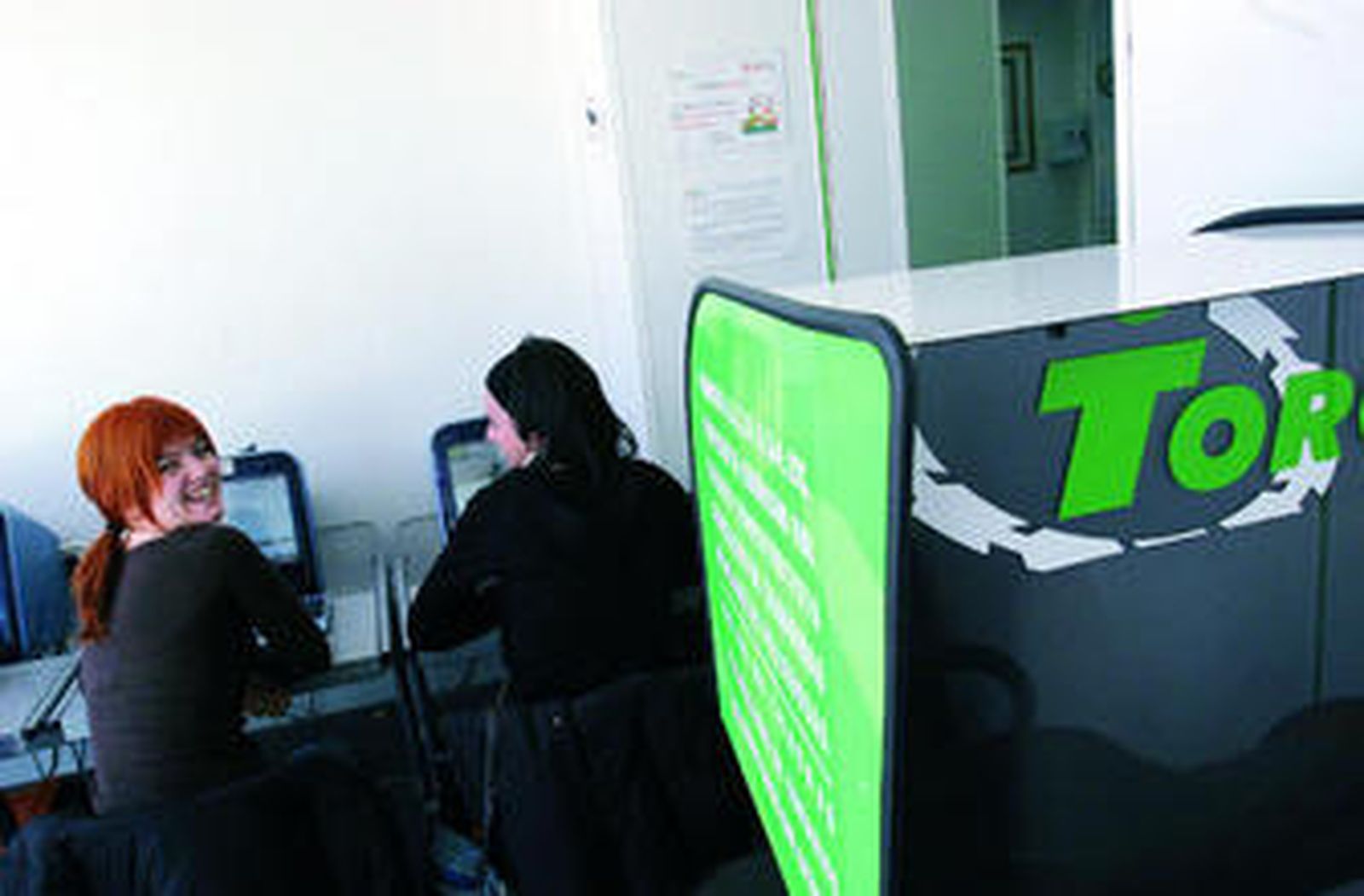 Dos alumnas de la autoescuela hacen test en ordenadores.