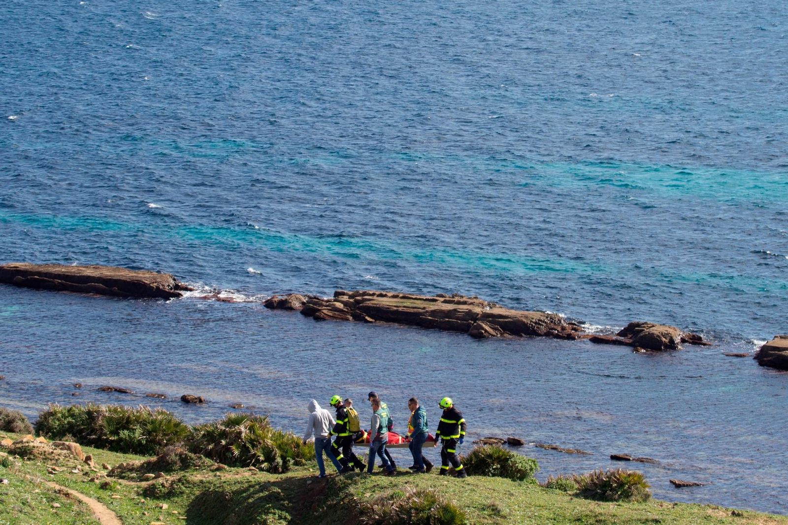 El equipo de rescate porta el cadáver de Óscar Maquera, en enero de 2020, en las inmediaciones del cuartel de Oliveros, en Tarifa.