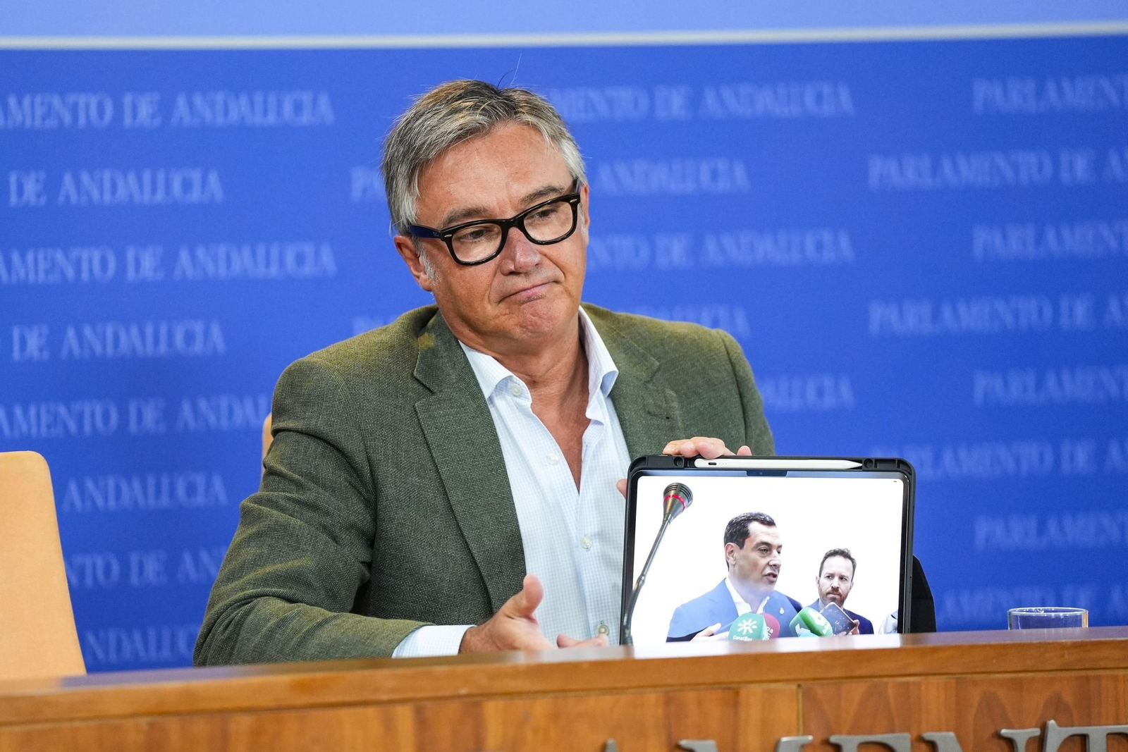 El portavoz de Vox, Manuel Gavira, muestra una imagen de Juanma Moreno.