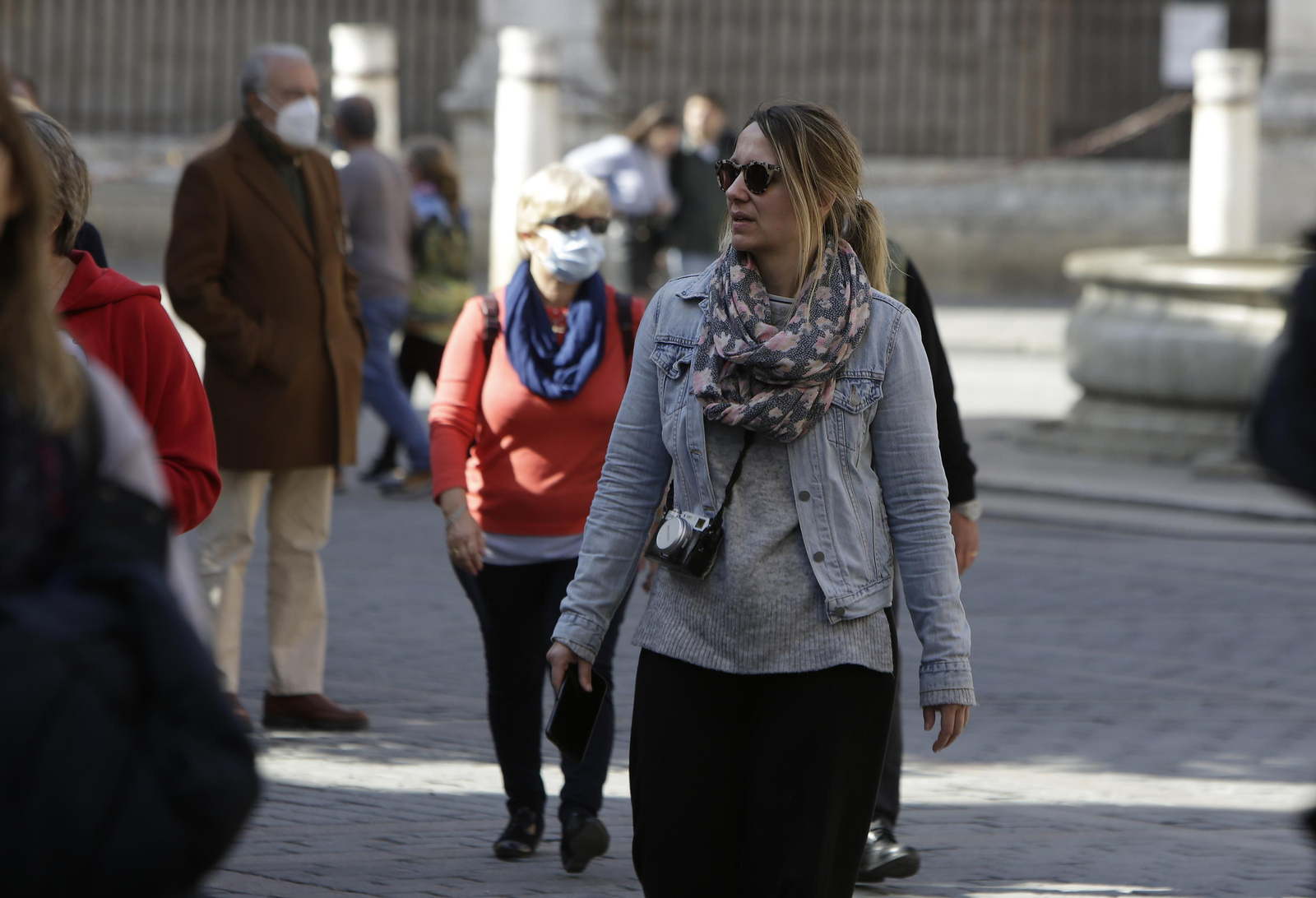 Una mujer sin mascarilla, en el centro, entre otro grupo de personas con ella puesta.