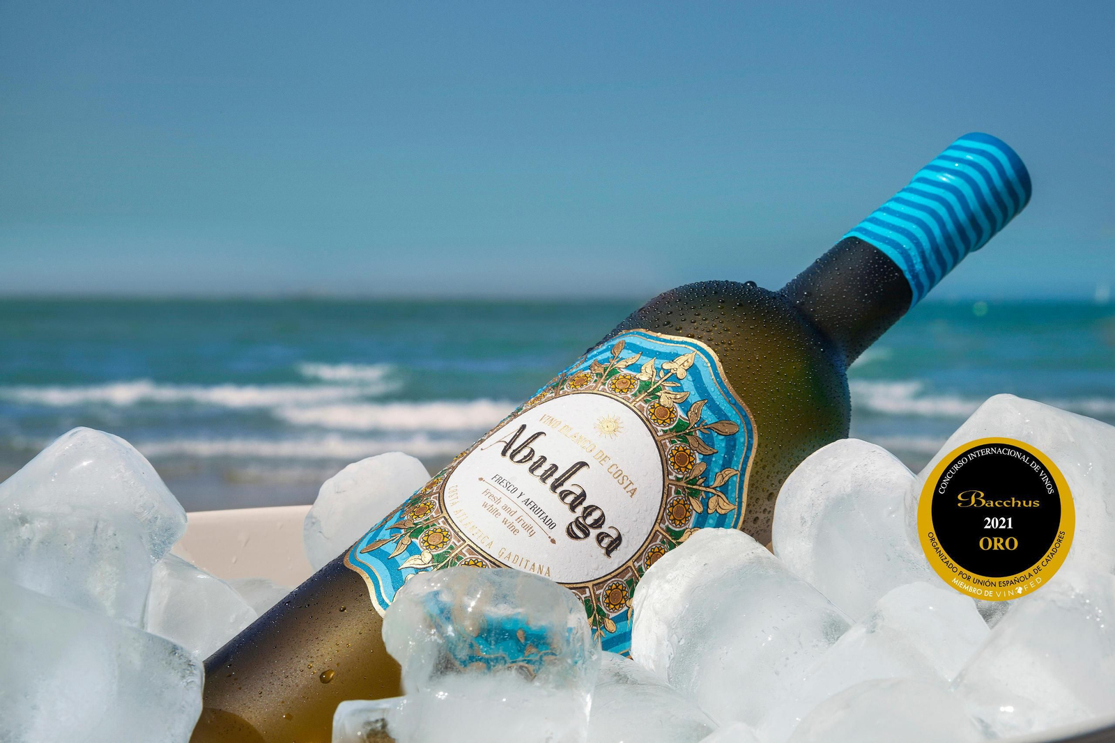 Botella de Abulaga, el nuevo vino blanco del Grupo Caballero fotografiado junto al mar.