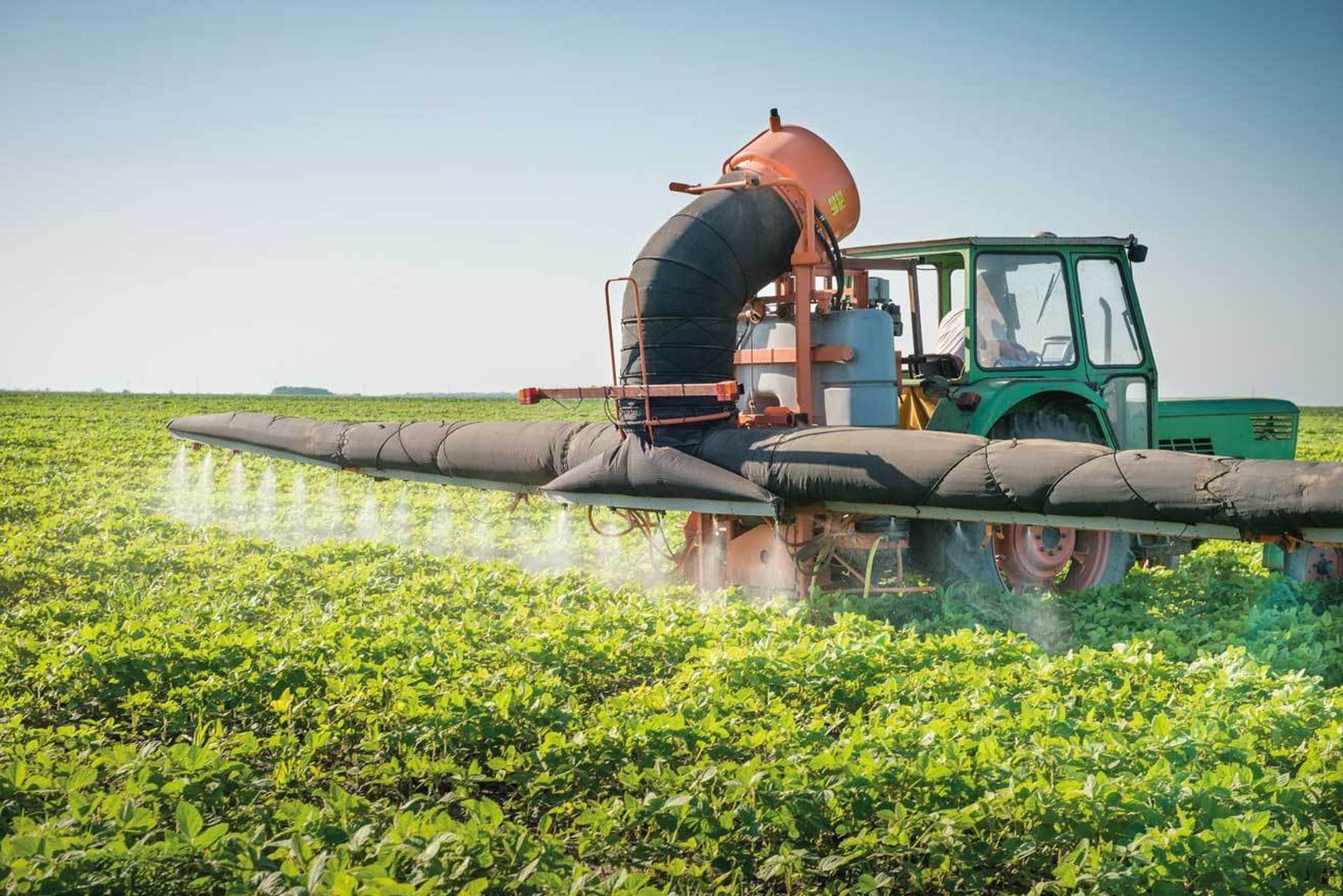 Maquinaria agrícola fumigando un cultivo.