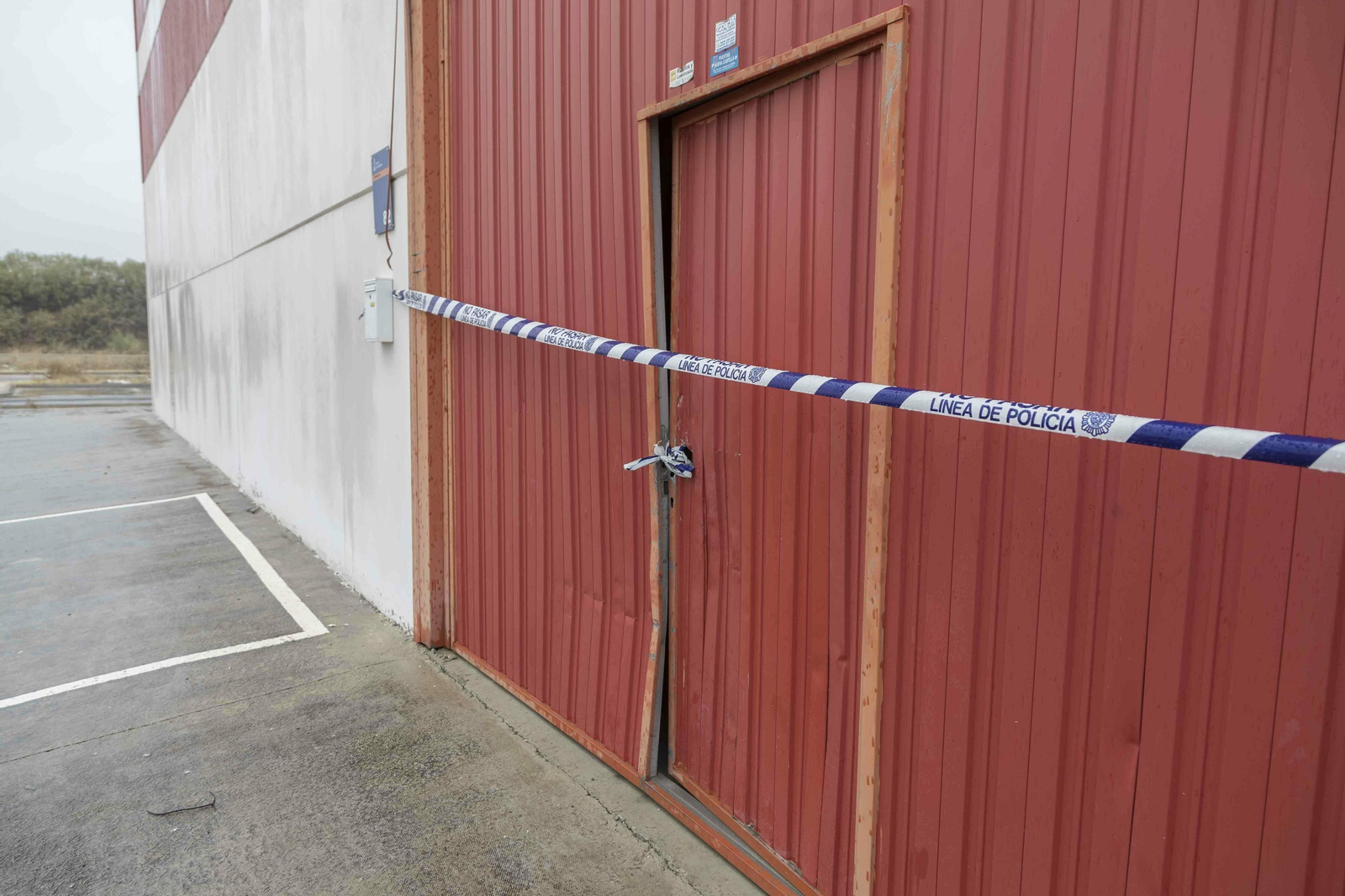 La puerta de la nave, forzada y con el precinto de la Policía Nacional.