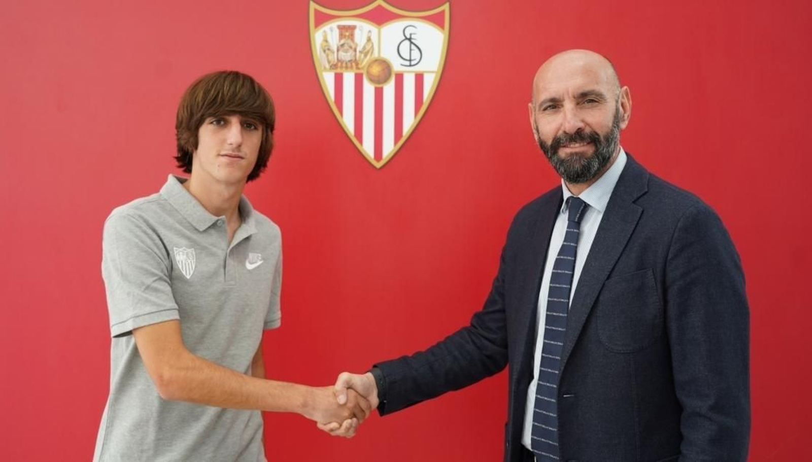 Bryan estrecha la mano de Monchi tras rubricar su nuevo contrato.