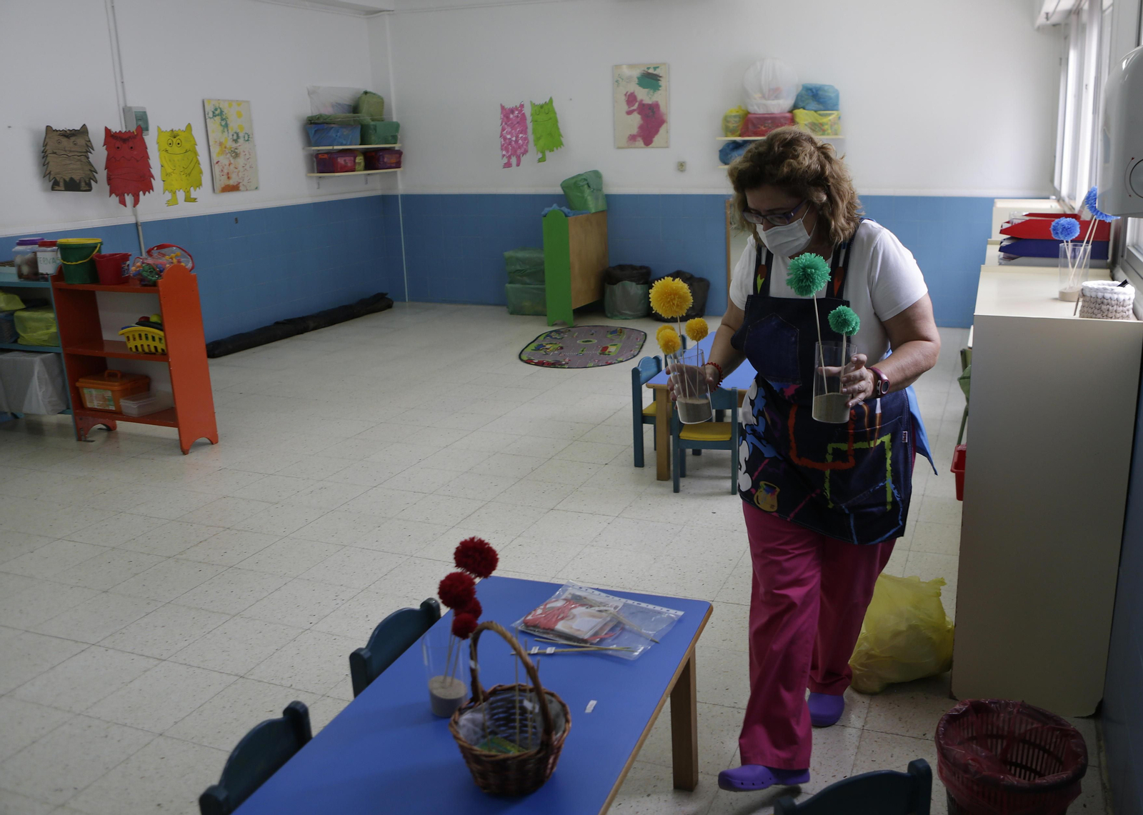 Una monitora de Infantil prepara el aula de una guardería.