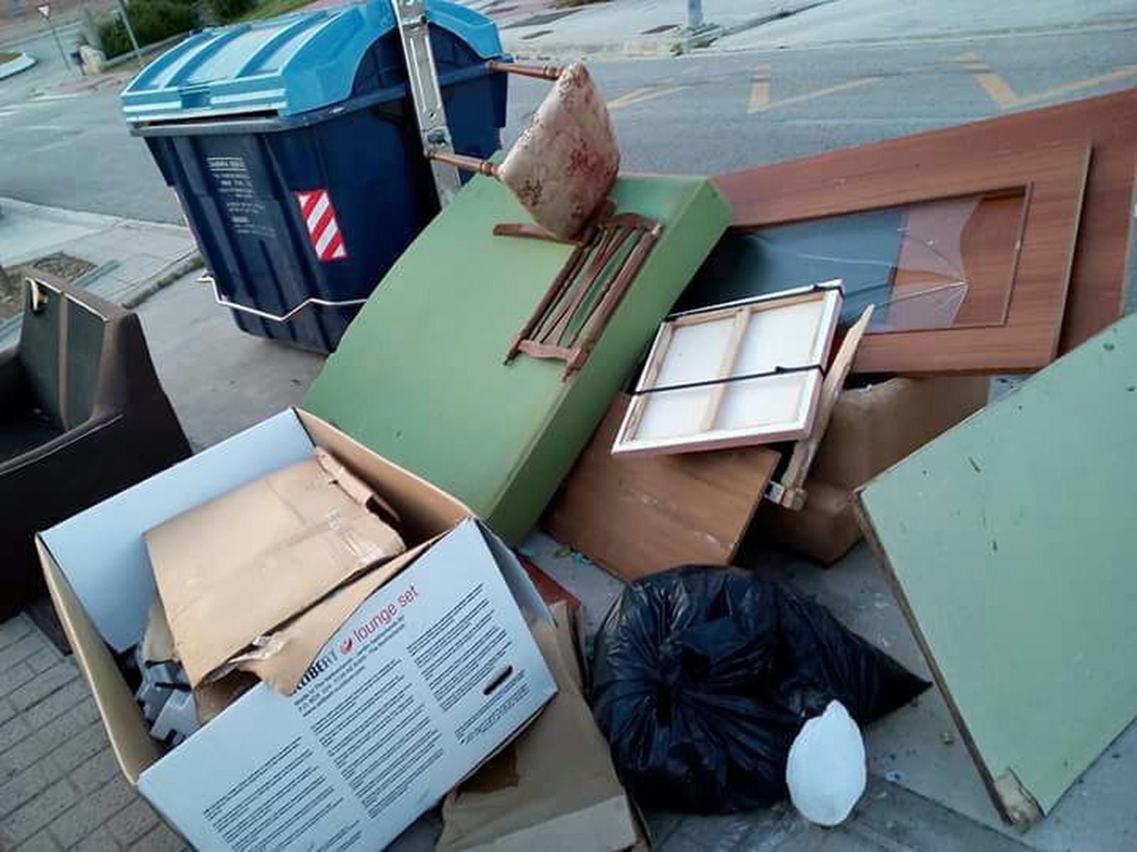 Muebles tirados junto a un contenedor en una calle de Vélez-Málaga.