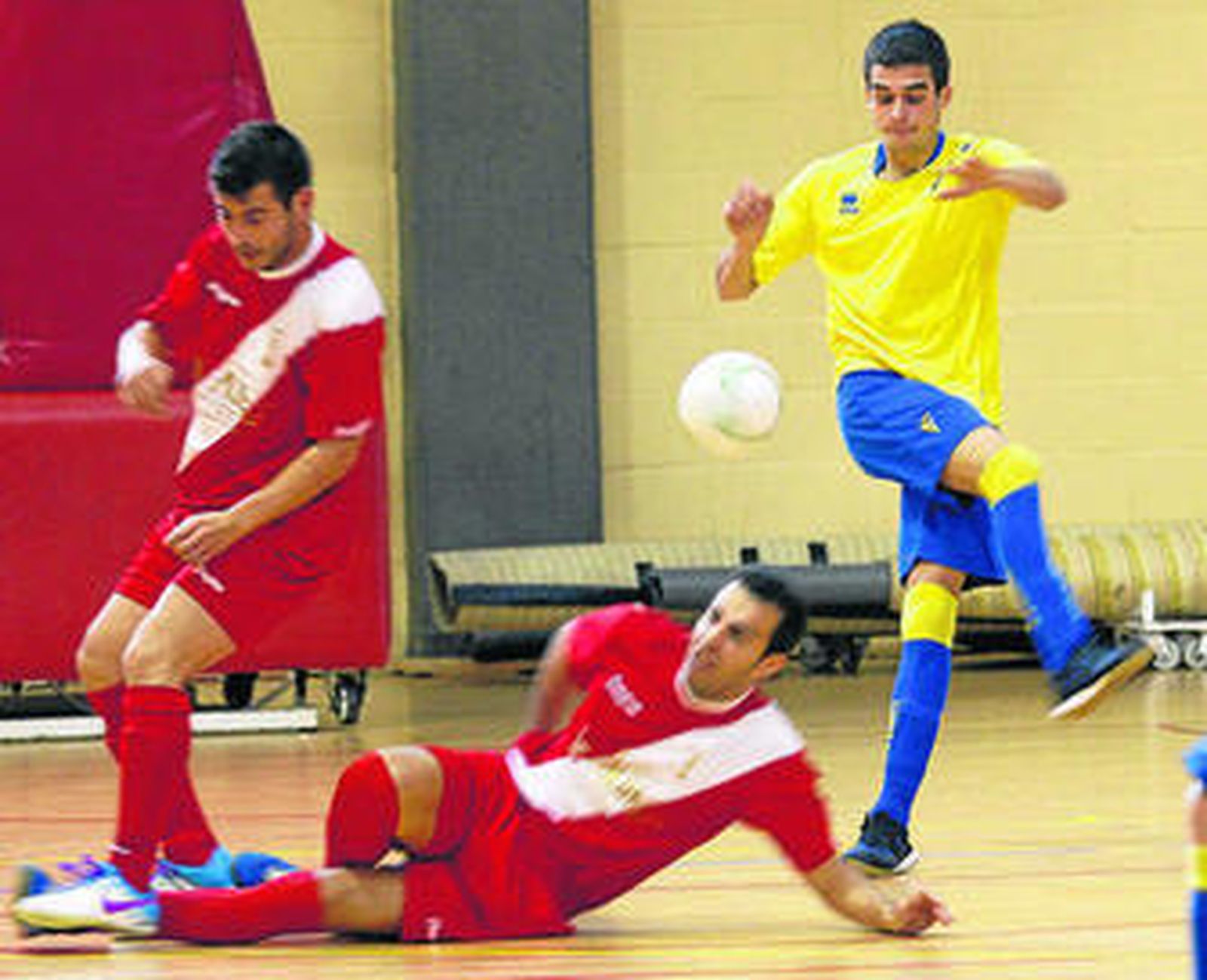 Dos jugadores del Alchoyano intentan tapar el lanzamiento de Cucu.