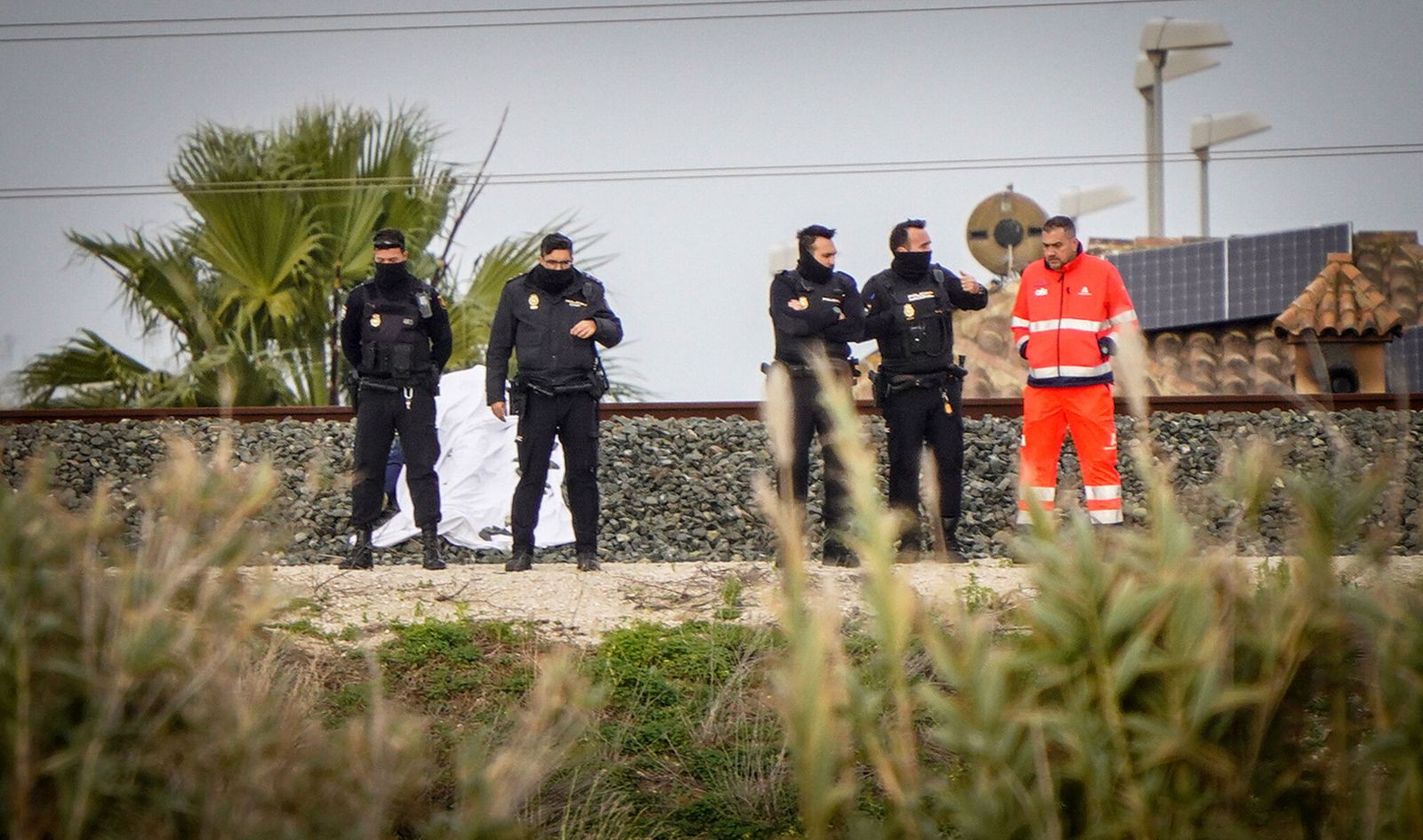 Varios policías y un sanitario junto a las vías del tren en Jerez, donde ha tenido lugar el suceso.