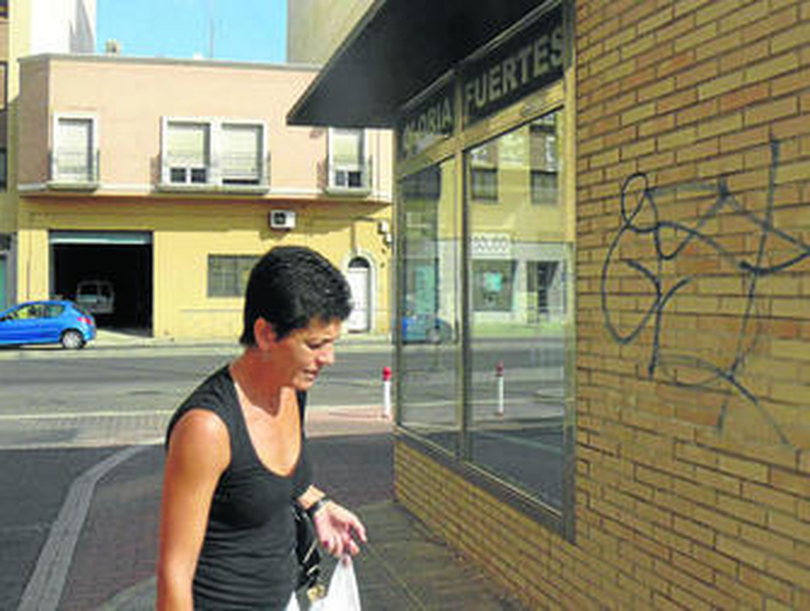 Una mujer pasa junto a una de las entradas del parking Gloria Fuertes.