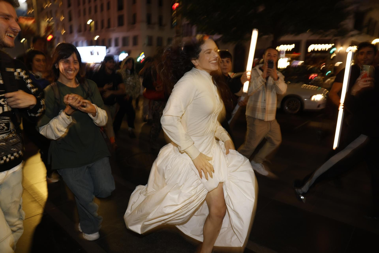 Rosalía corriendo perseguida por sus fans por las calles de Madrid.