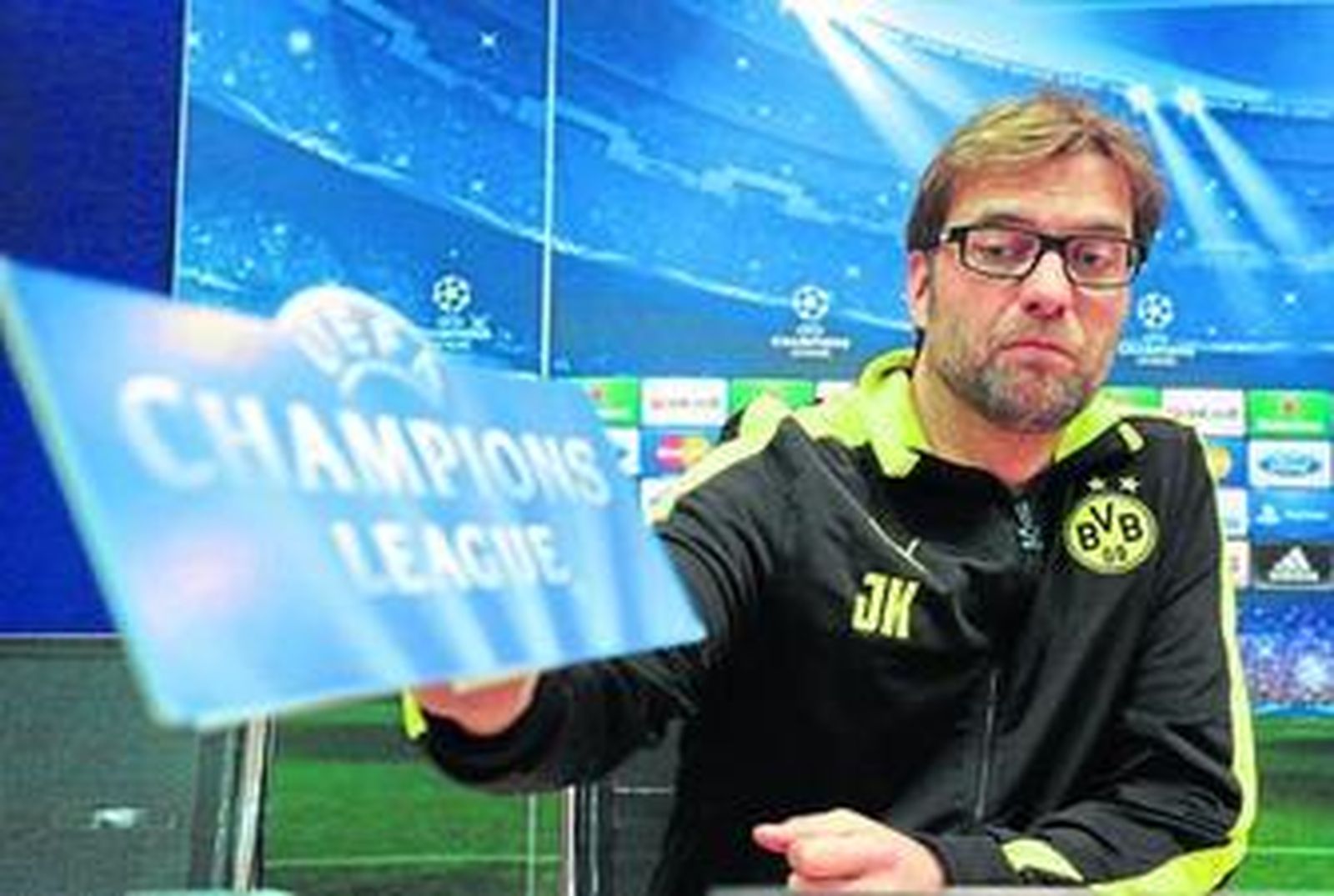 Jürgen Klopp juguetea con el cartel de la Champions durante la conferencia de prensa celebrada ayer.