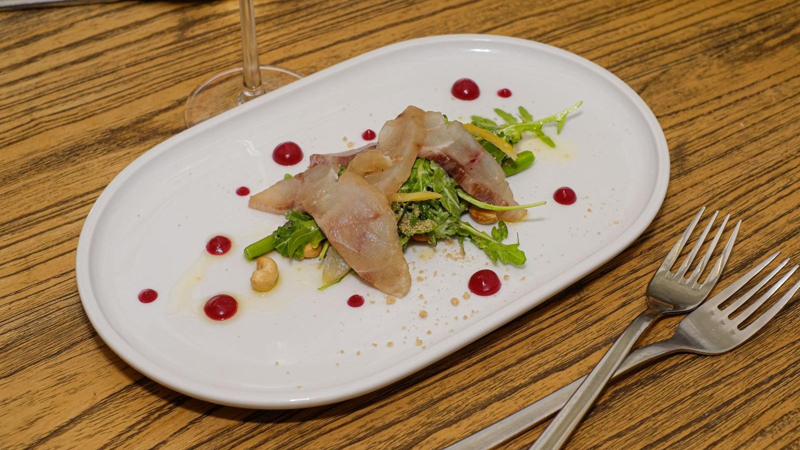 Pequeña ensalada de corvina ahumada, espárragos verdes y anacardos