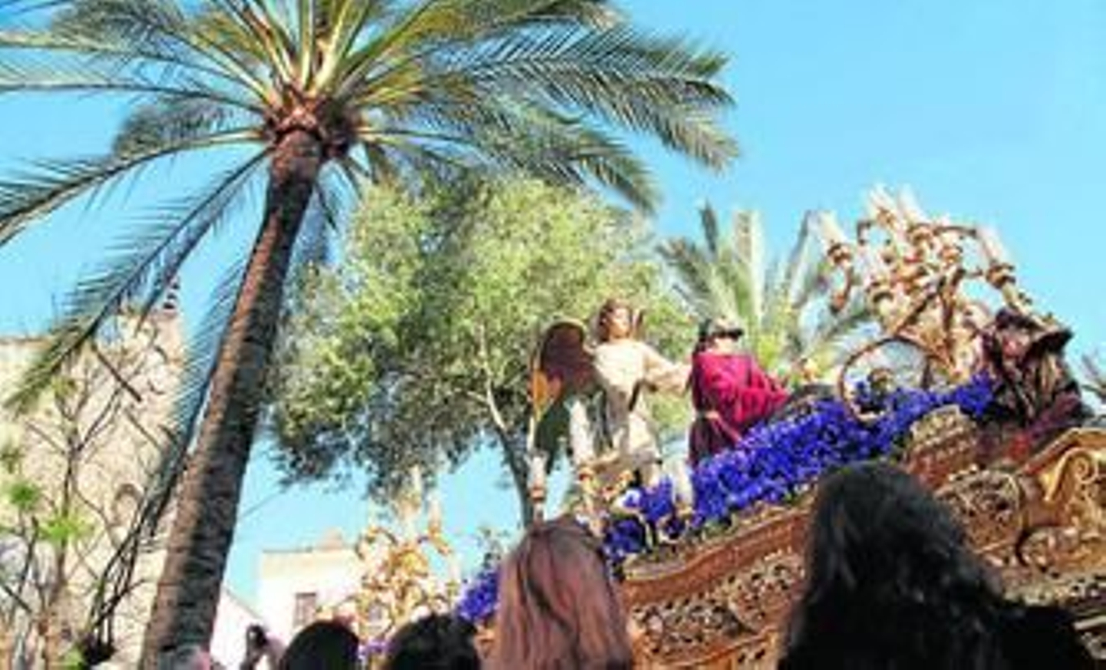 Nuestro Padre Jesús Orando en el Huerto, con el cielo abierto y enmarcado por las palmeras de la alameda Cristina, tras iniciar su camino.