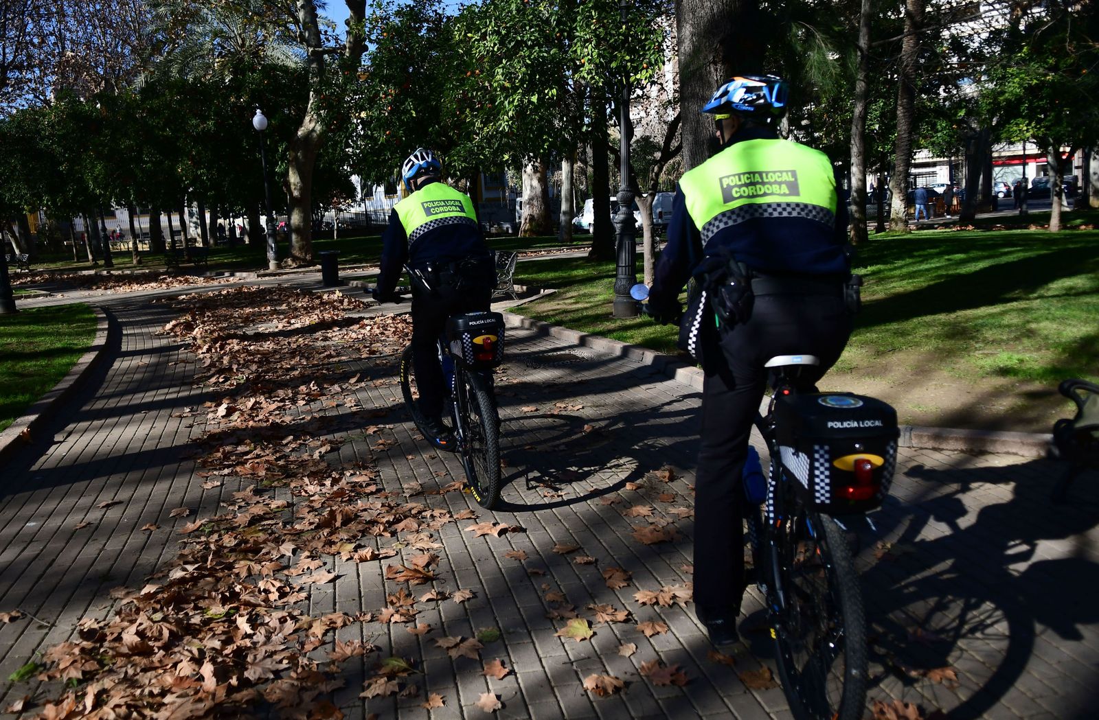 Dos agentes de la Policía Local patrullan en bicicleta por el parque de Colón.