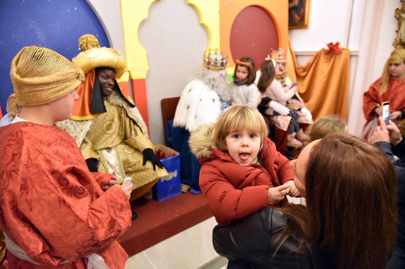 Un niño sonríe ante los Reyes Magos en la Capilla de Europa de Algeciras.