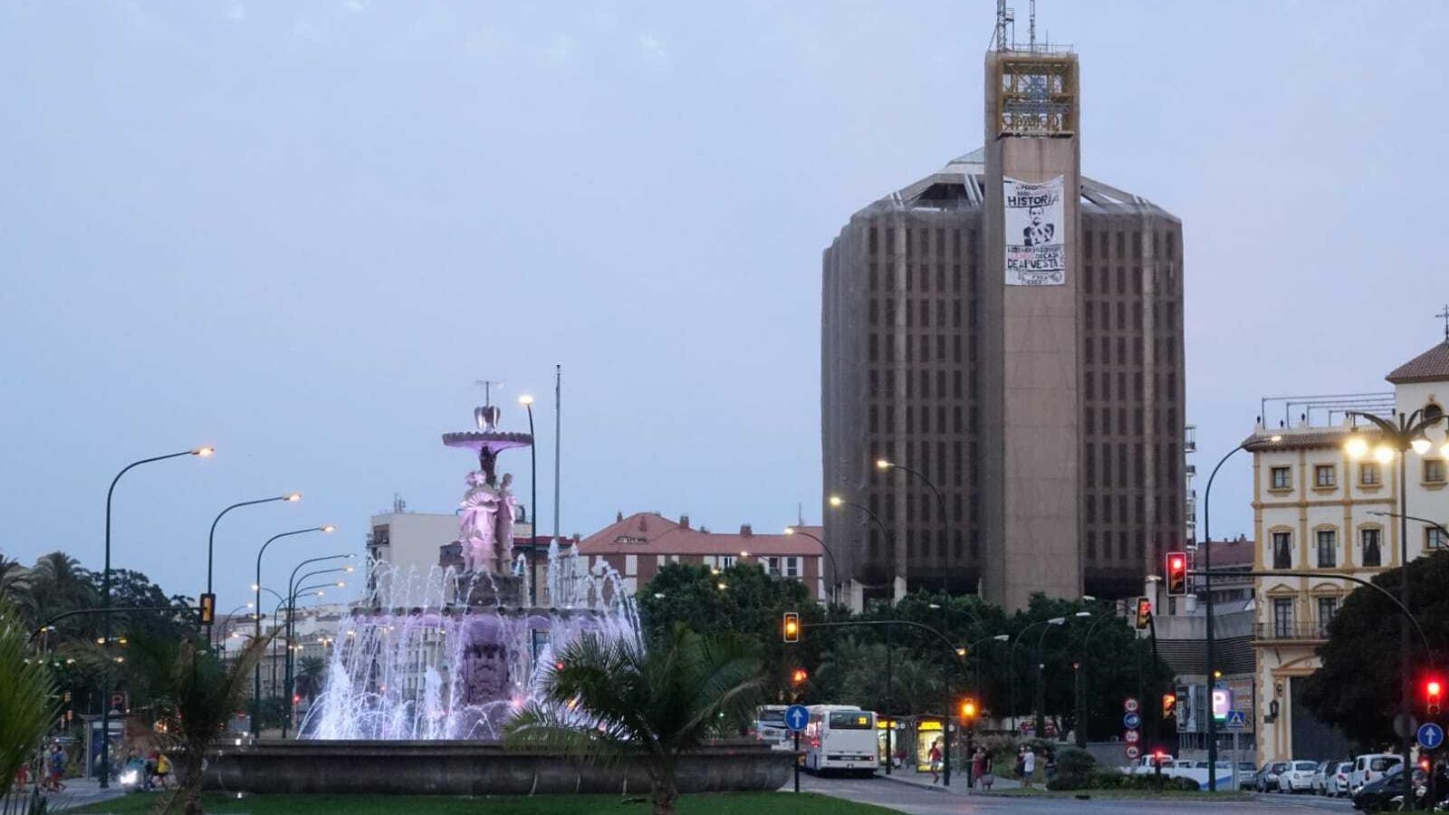 Vista del edificio del Correos de Málaga, con la pancarta.